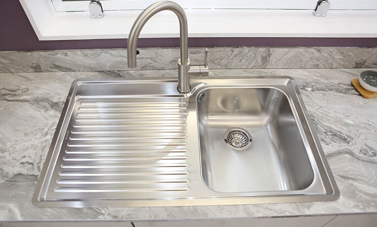 Stainless steel sink set in a grey marble worktop