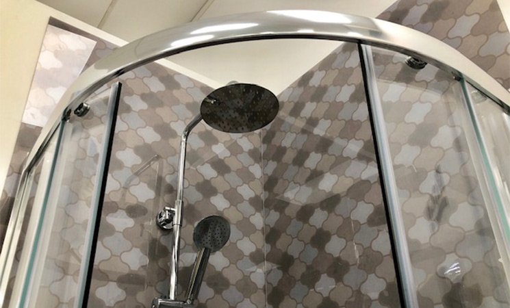 shower head in enclosure with tiles