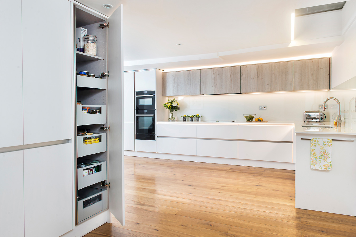 Beautiful white and oak fitted kitchen with a pantry on show