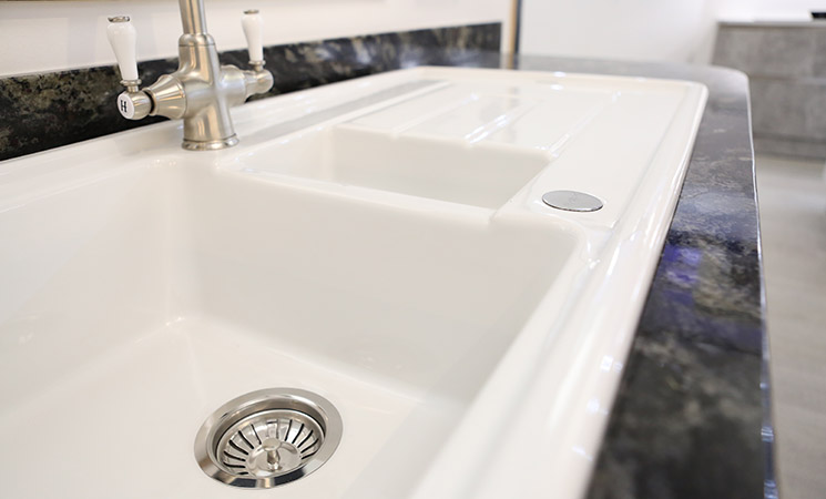 White ceramic sink in a country style fitted kitchen 