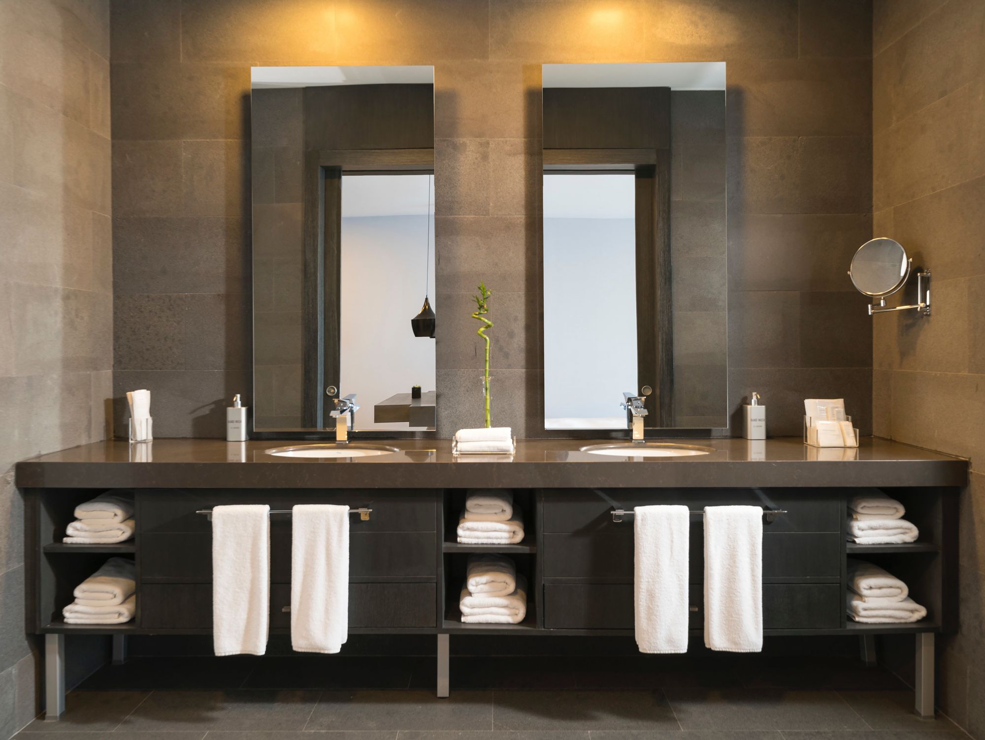 Dark bathroom with twin sinks and dark cabinetry