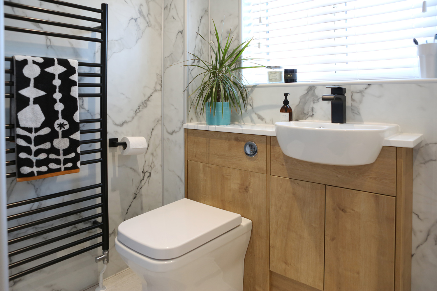 Bathroom with black sanitaryware. Black tap and heated towel rail