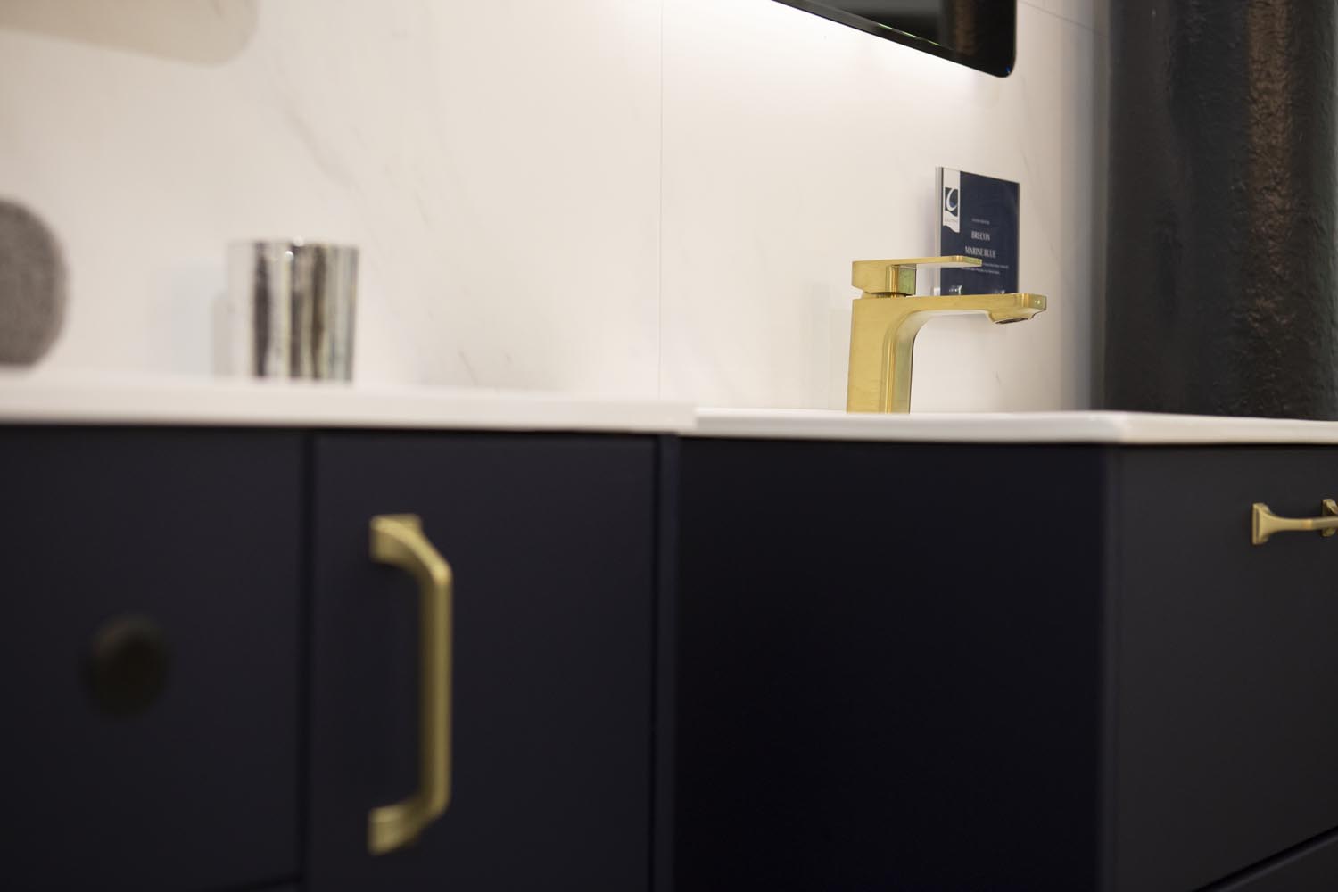 Brass taps and dark navy cabinetry for a dark bathroom