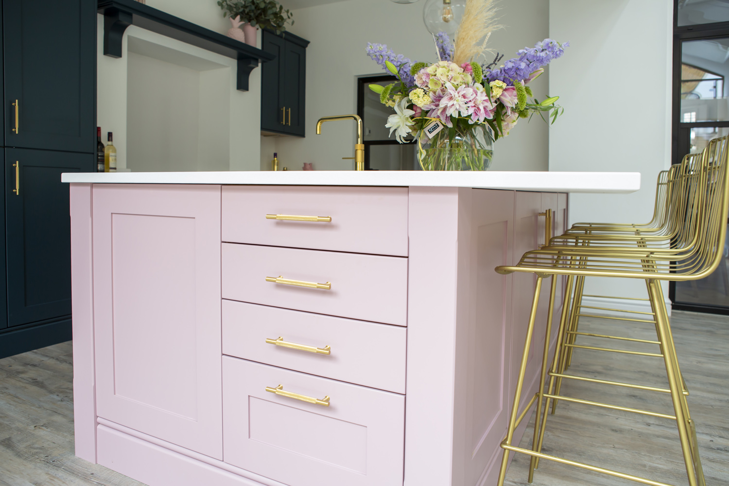 Dusky pink kitchen island with gold bar stools
