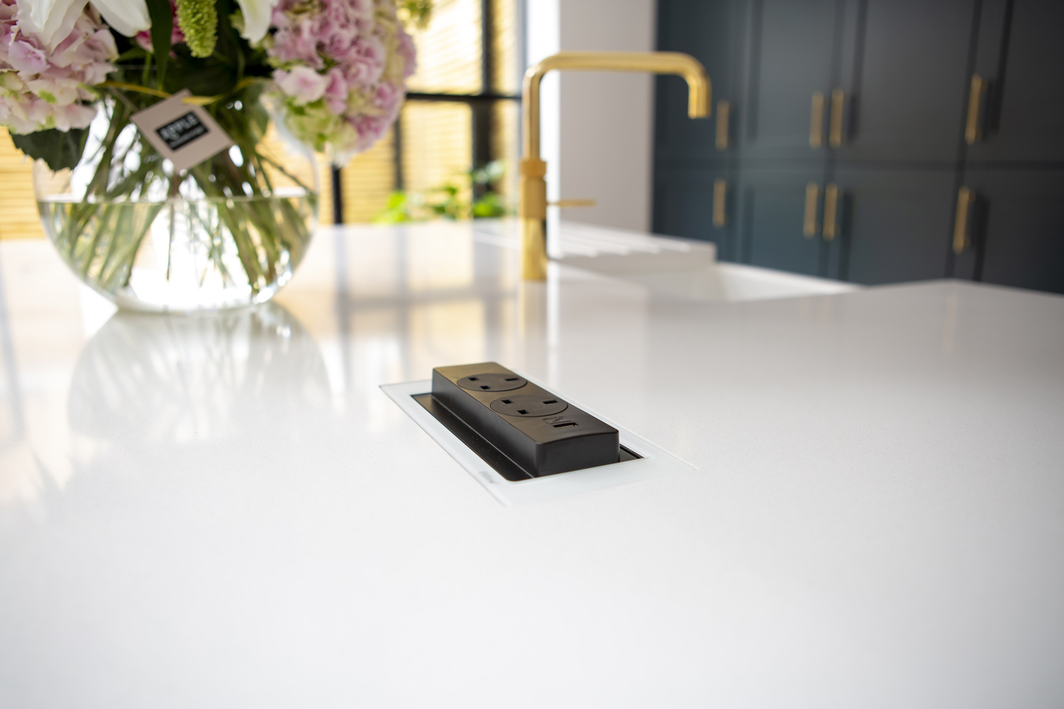 Plug socket revealed in a kitchen island worktop 