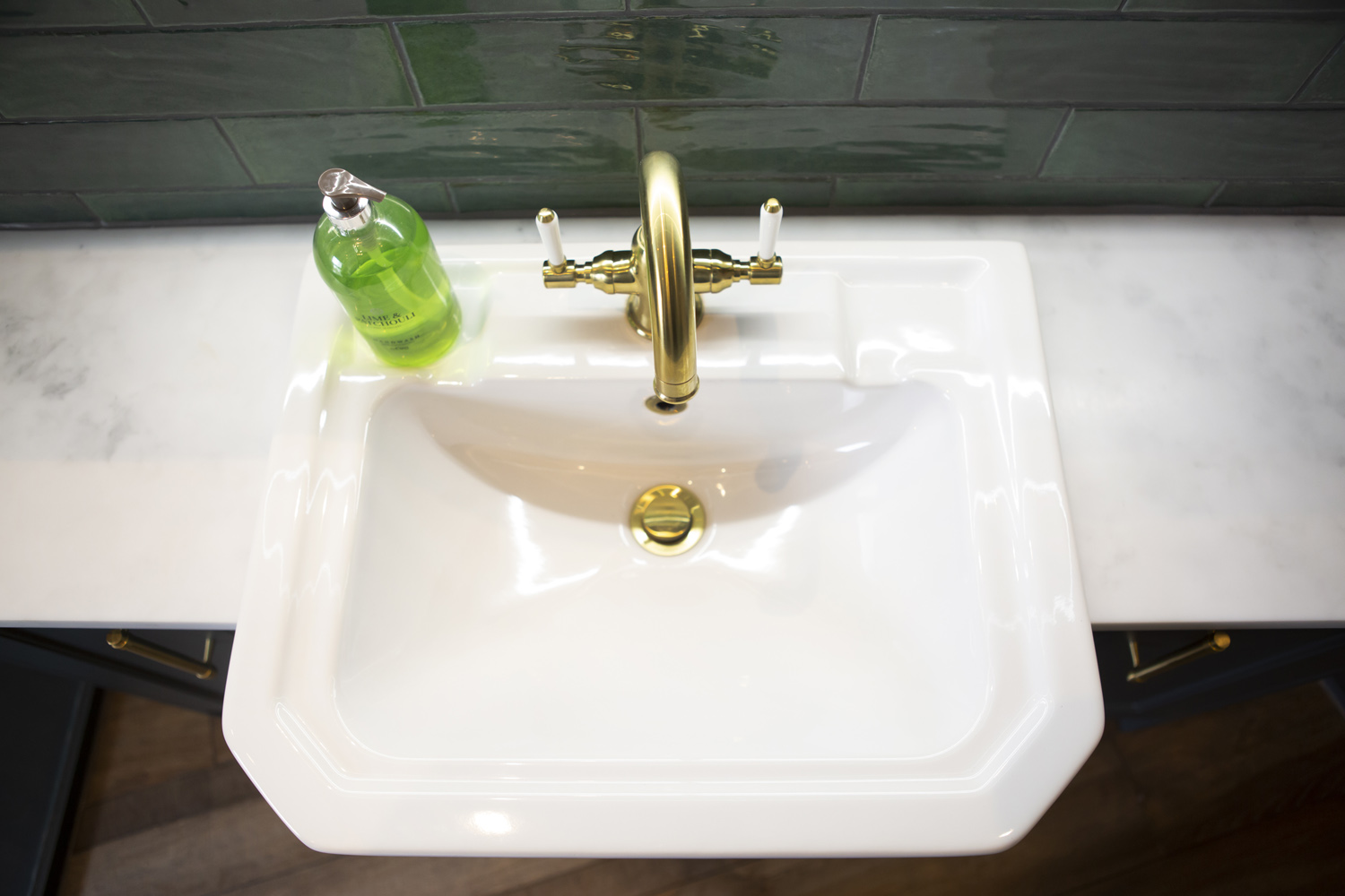 Sink with green tiling in traditional bathroom