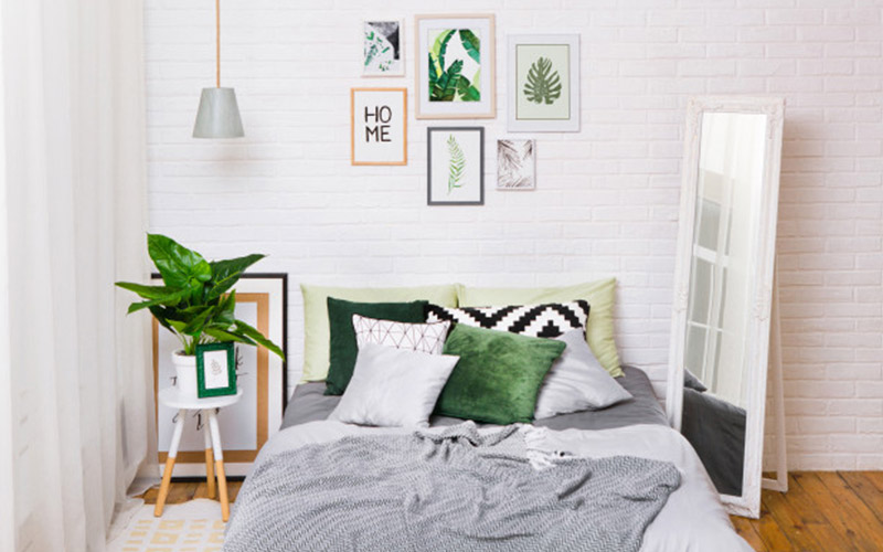 A bedroom with white walls and green accessories