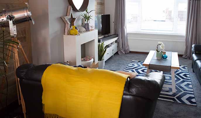 Natural wood walls made from wood pallets in a grey and white room with yellow and indigo blue accents